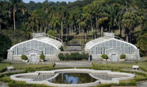 Vista do Jardim Botânico de São Paulo, mostrando suas estufas e lagoas em um dia ensolarado.
