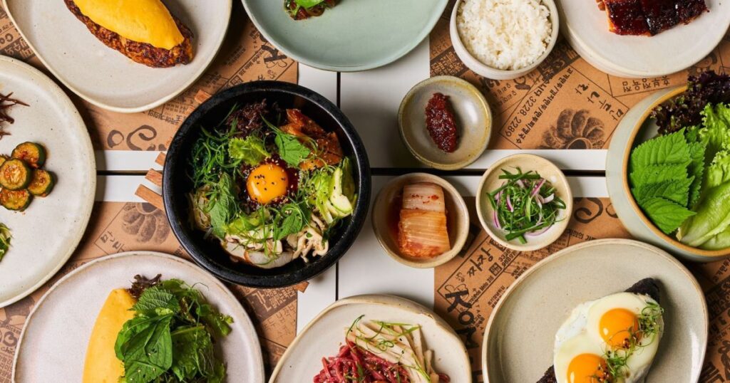 Pratos de culinária asiática com destaque para sushi, tempurás e bibimbap em um ambiente típico de São Paulo