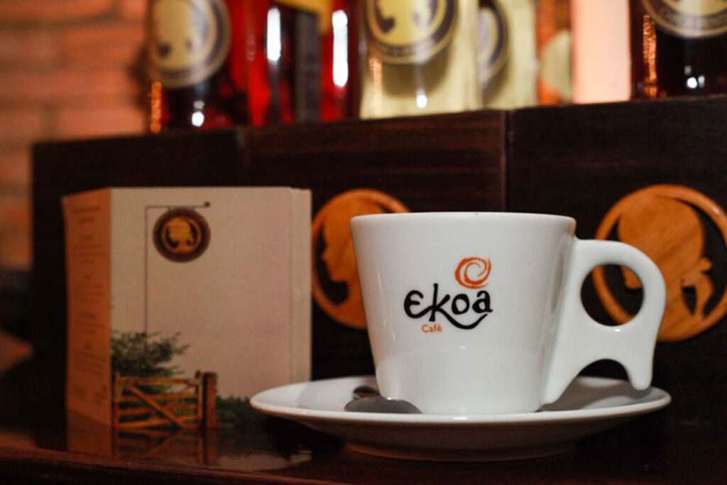 Ambiente acolhedor do Ekoa Café em São Paulo, com mesas, decoração aconchegante e clientes interagindo.