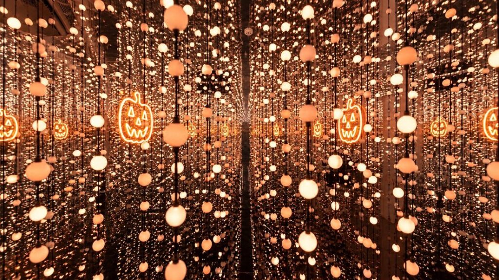 Decoração temática de Halloween na Dopamine Land em São Paulo com abóboras, morcegos e teias de aranha.