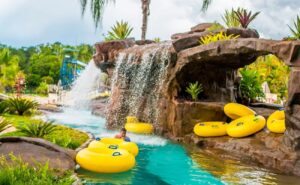 Família se divertindo no Hotel Fazenda Ramon com piscinas e uma cachoeira ao fundo